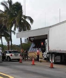 Trailero baleado; su unidad arrolló la caseta de cobro