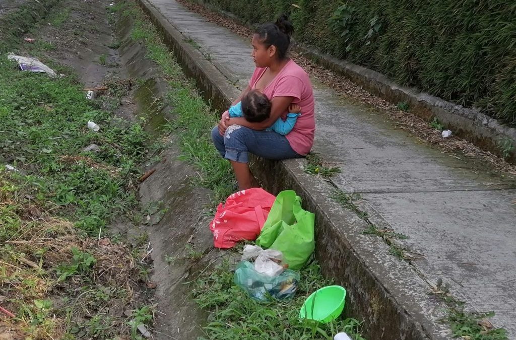 Camina horas sobre carretera en busca del sustento con su hija en brazos