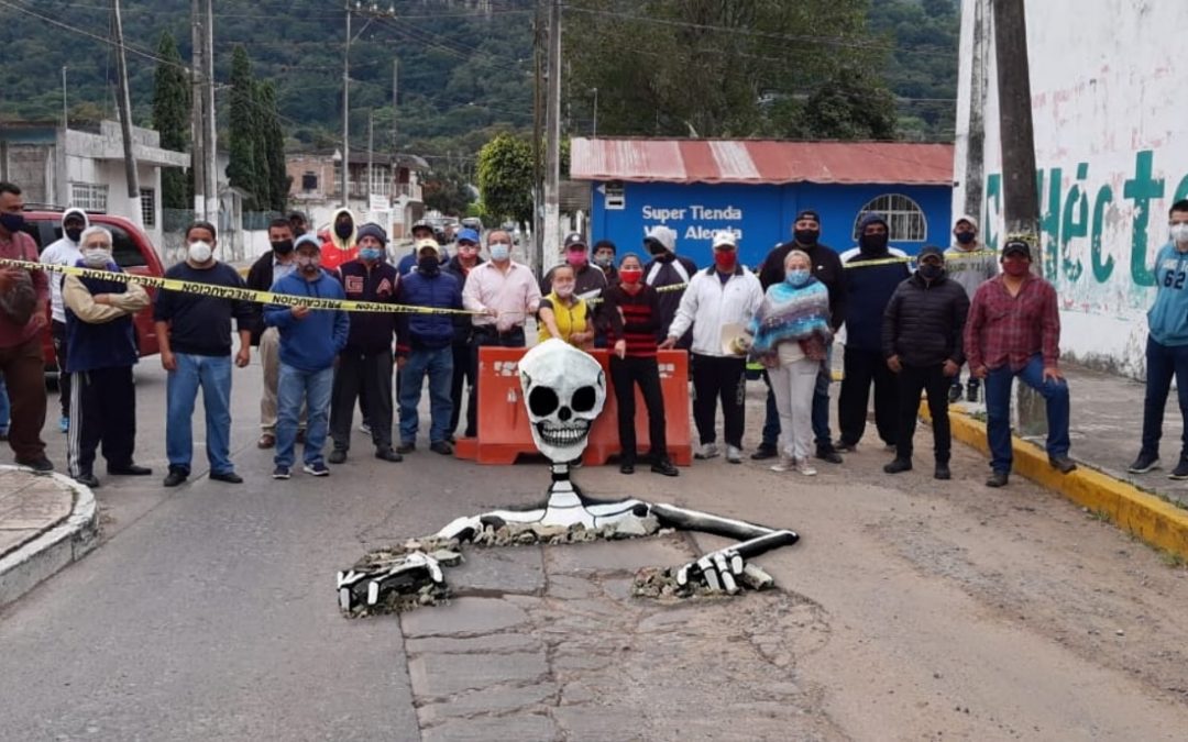 Con calaveras de todos los tamaños y gustos, así fue como habitantes de Ciudad Mendoza visibilizaron los baches que entorpecen la circulación vial sobre las principales calles de su municipio.
