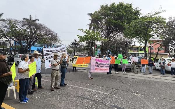 Maestros jubilados reclaman adeudos a la SEV y bloquean calle del centro